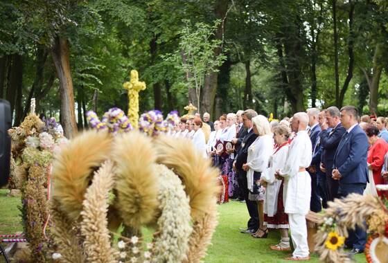 wieniec dożynkowy w tle ludzie na mszy św.