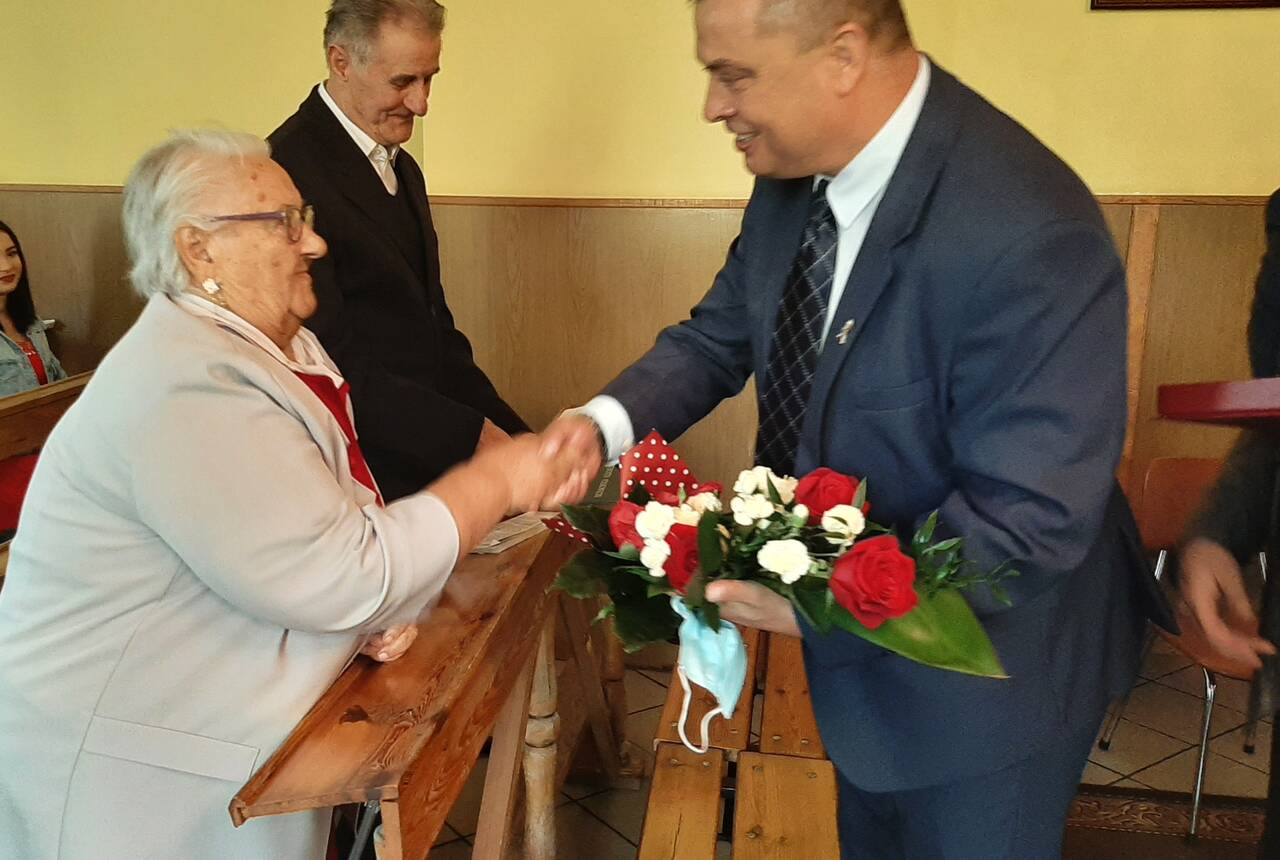 Zdjęcie z uroczystości Diamentowych Godów. Małżeństwo odbiera gratulacje od Przewodniczącego Rady Gminy Gaworzyce - Edwarda Białka.