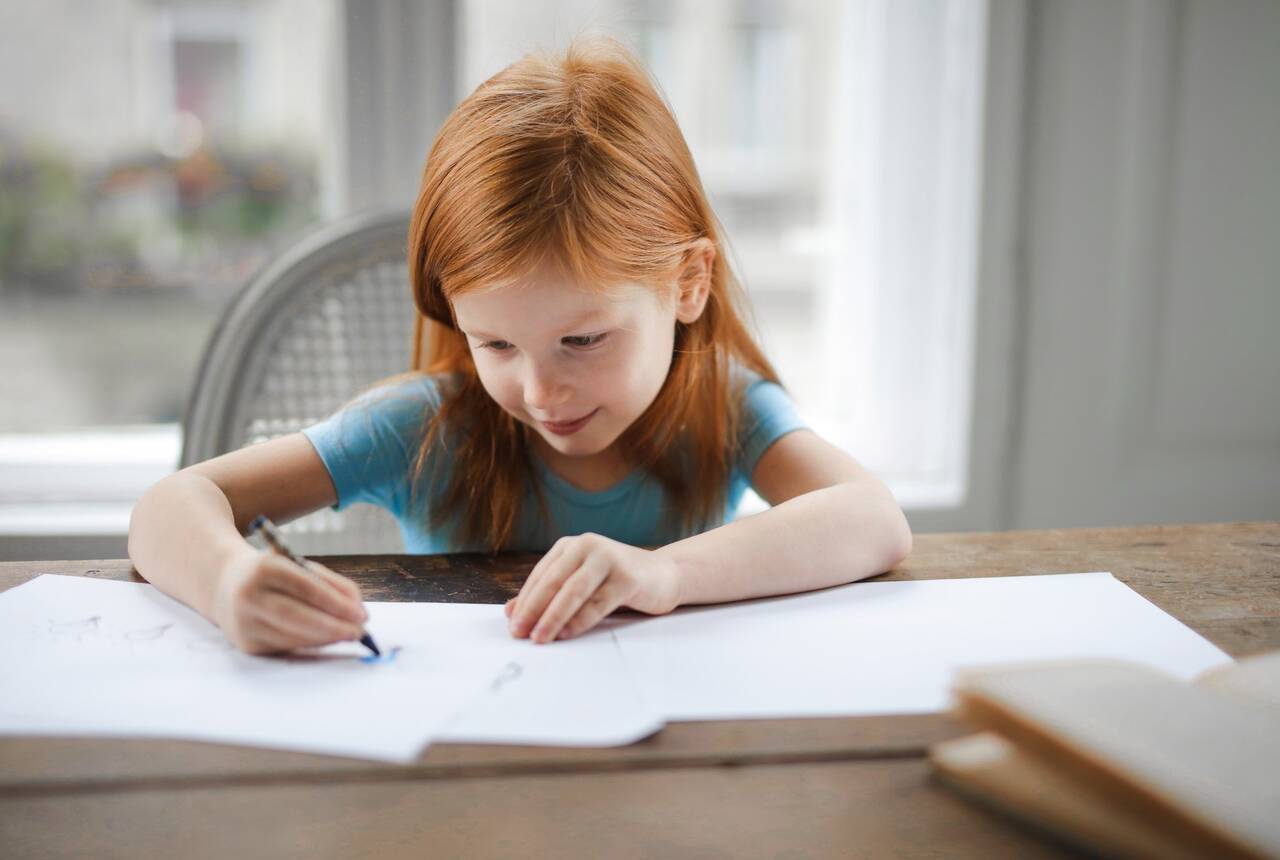przykładowe zdjęcie dziewczynki rysującej coś na kartce