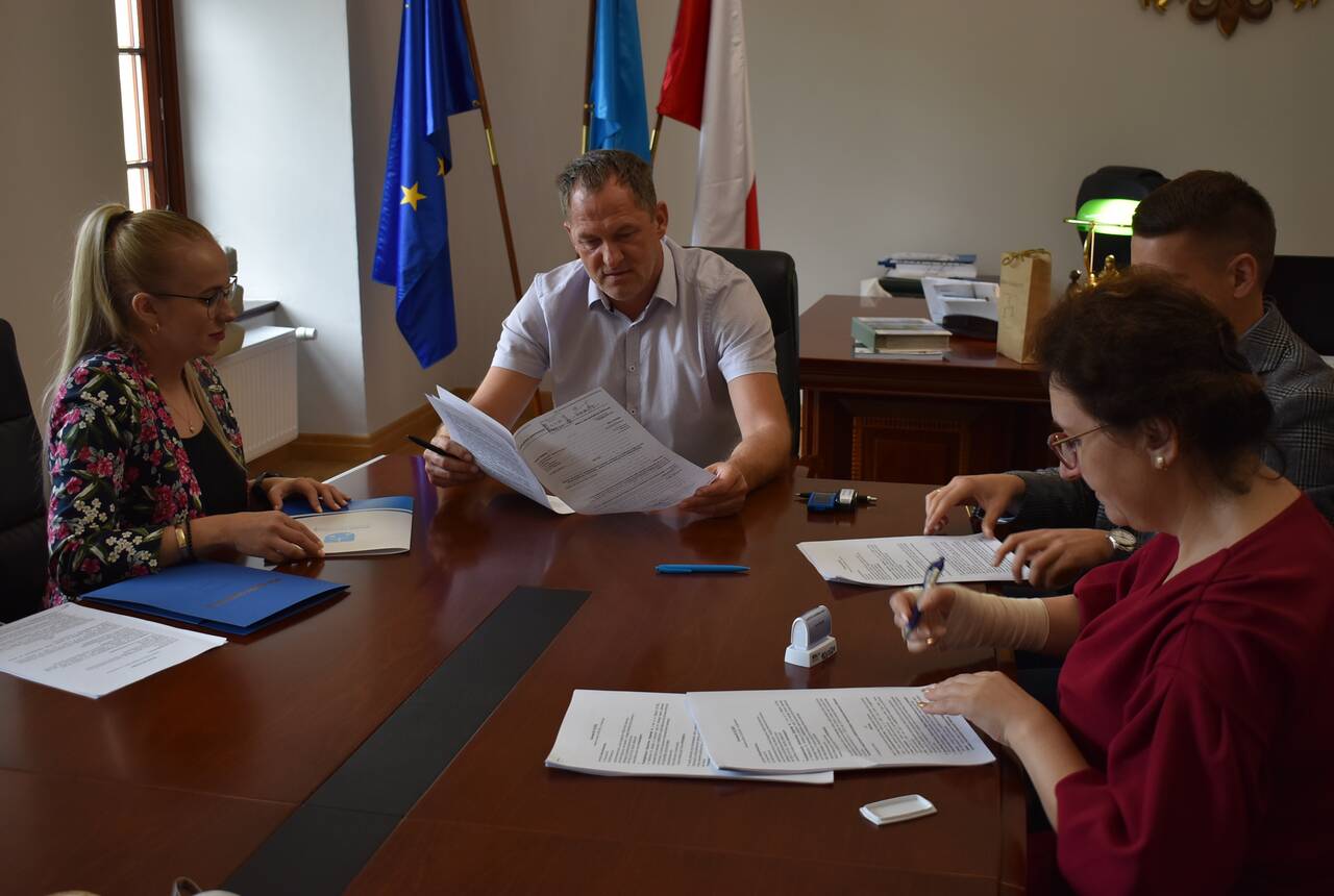Grupa ludzi biorących udział w podpisaniu umowy 